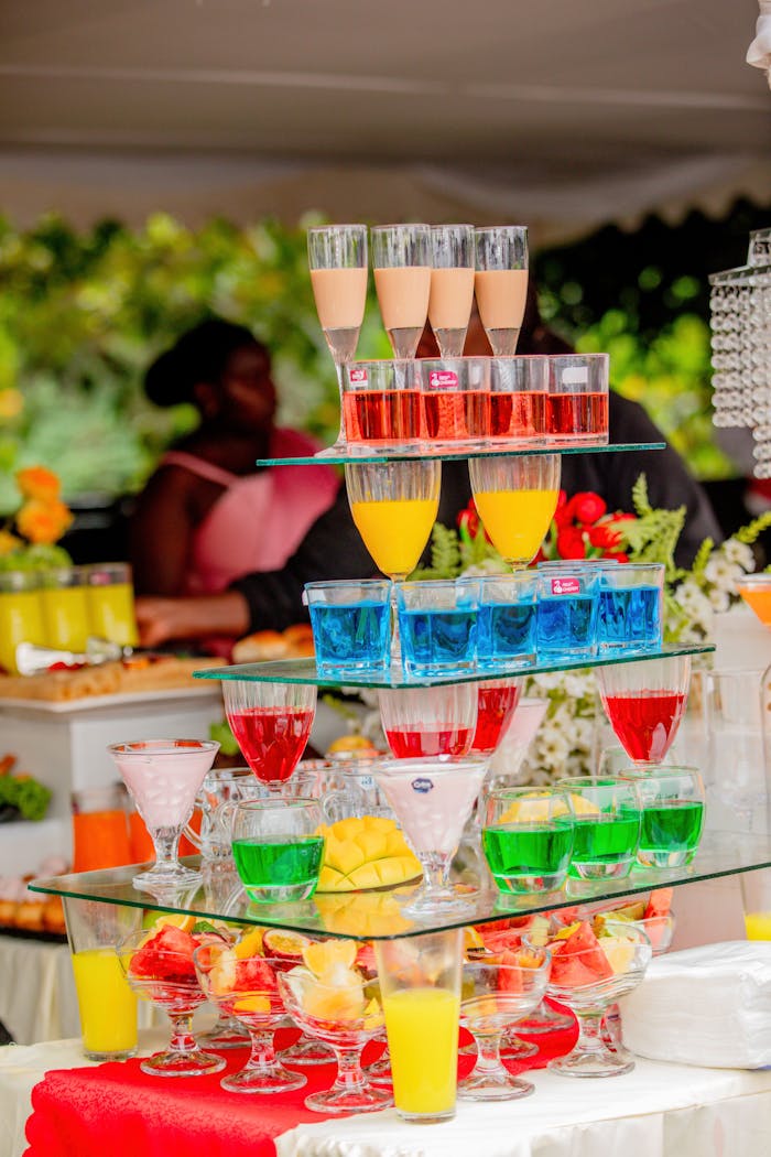 Vibrant cocktail stand with colorful drinks at an outdoor gathering.